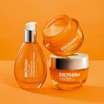 Flacon et pots de soin Biotherm Aquasource+ en verre orange, presentes sur fond orange vif, avec couvercles argentes et gel hydratant visible.