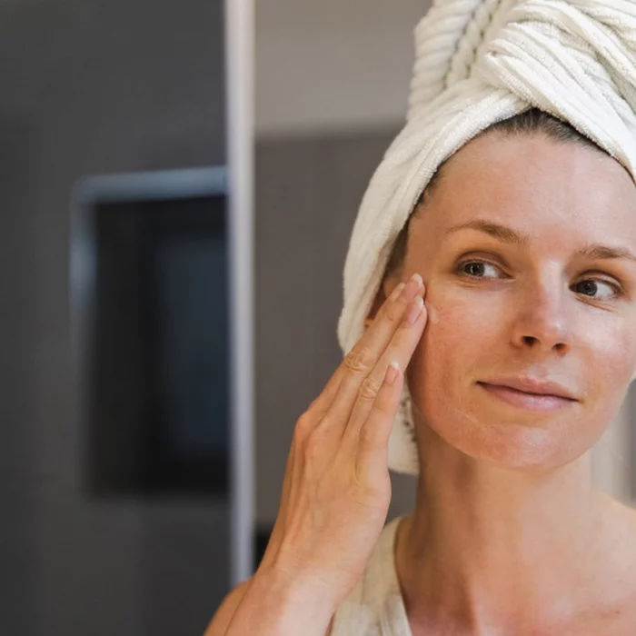 Femme qui touche sa peau mixte