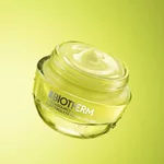 Flacon transparent et tube jaune Biotherm Aquasource+ Eau de Lait Demaquillante, avec gouttelettes d’eau visibles, sur fond vert degrade lumineux.