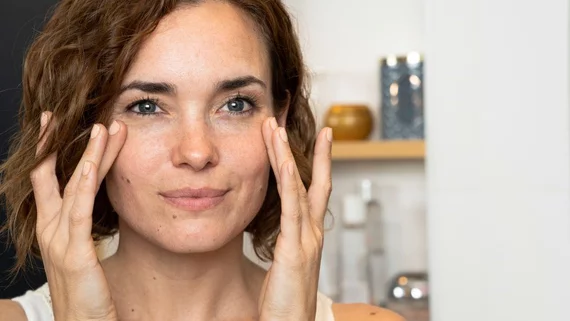 Femme qui touche ses taches de soleil