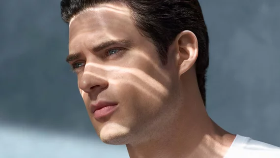 three-quarter man looking into the distance under the rays of the sun